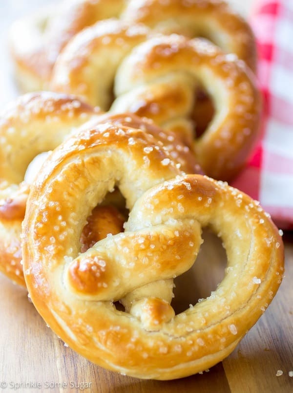 A tray of beautiful, golden pretzels with chunky salt on them.